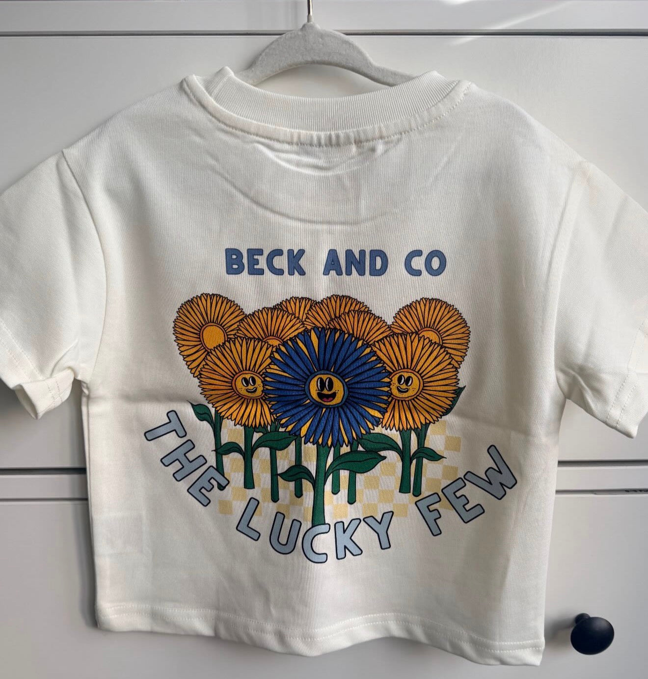 White t-shirt with floral design and 'Beck and Co' text on a white background
