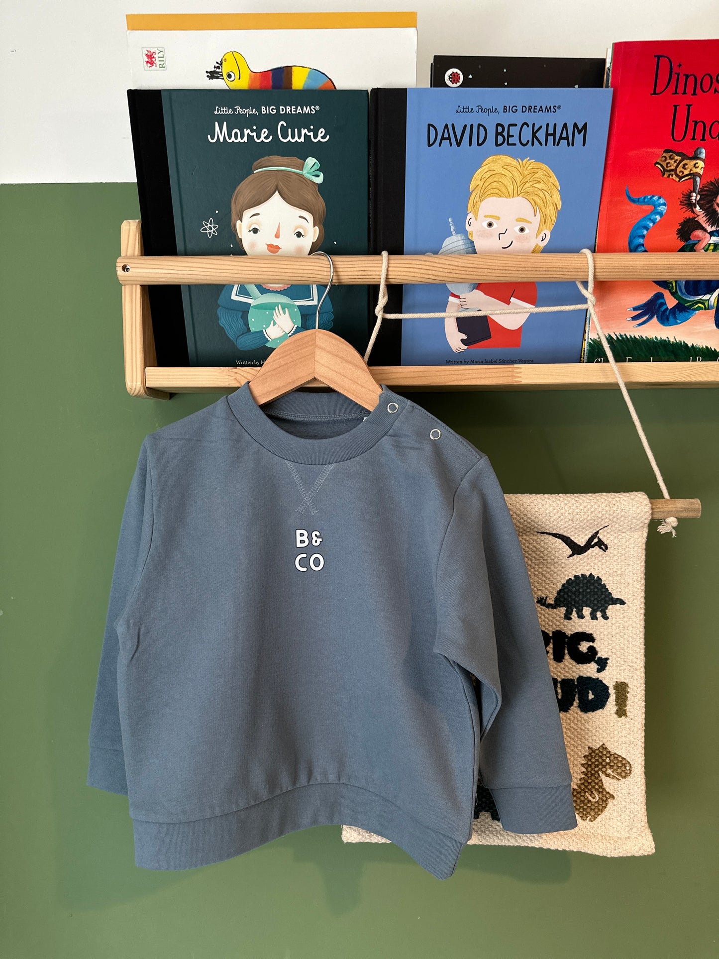 Children's books and a blue sweatshirt on a green background