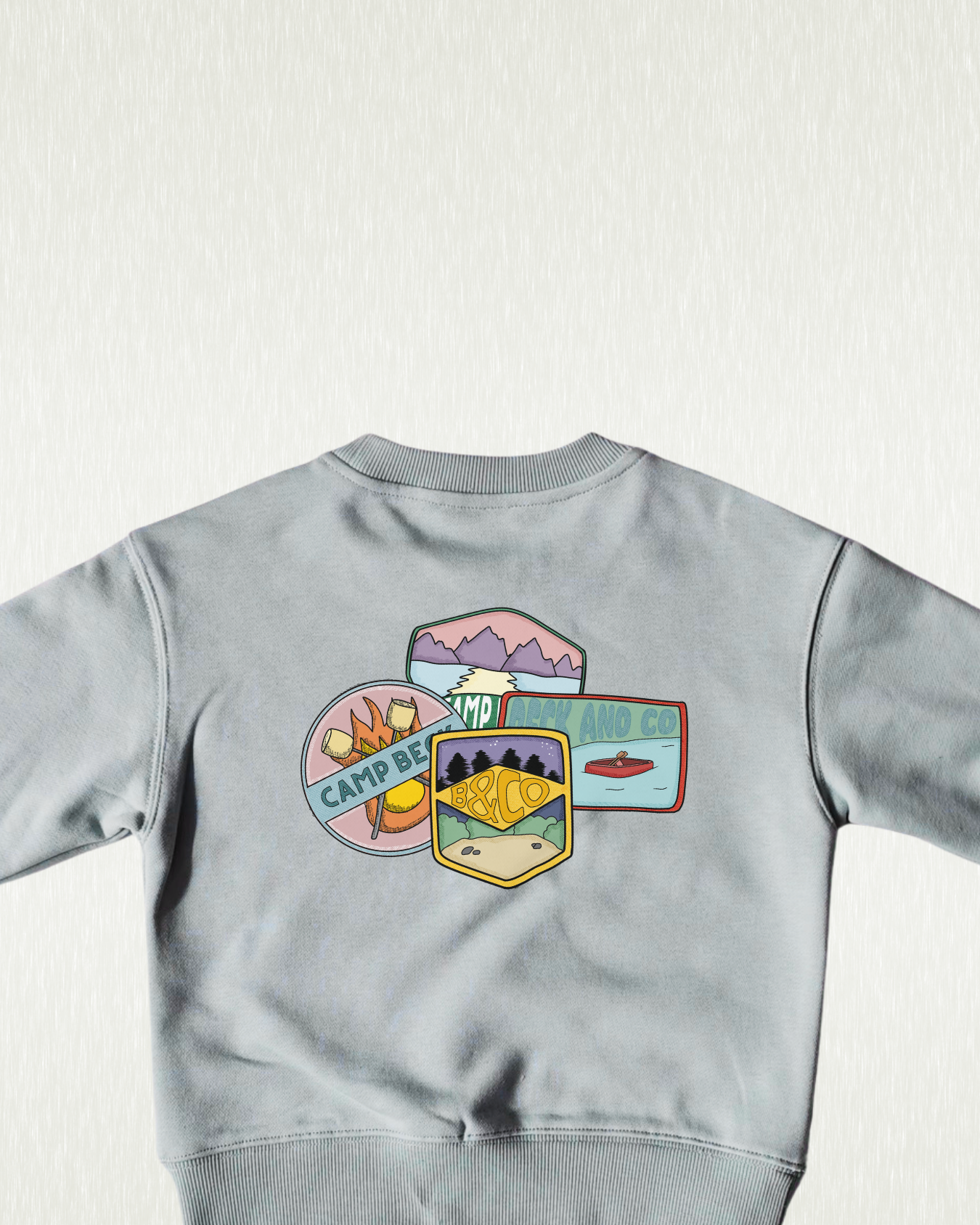 Gray sweatshirt with colorful camp-themed designs on a light gray background