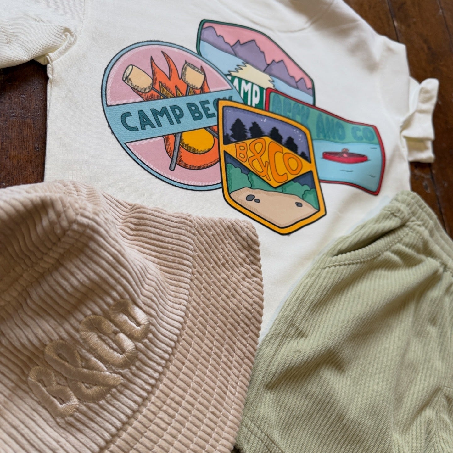 Children's t-shirt with 'Camp Beck' design on a wooden surface