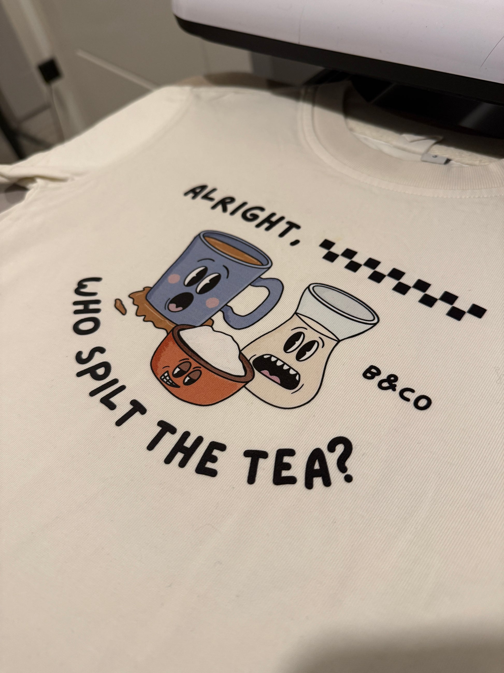 White t-shirt with cartoon teacups and text design on a white background