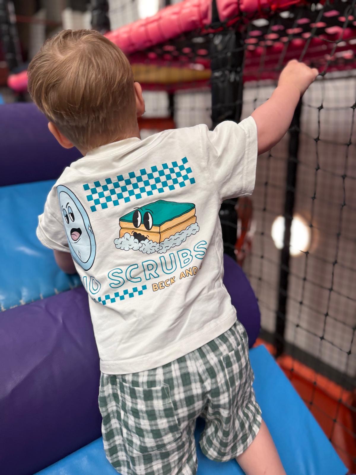 Child wearing a shirt with 'No Scrubs' branding in an indoor play area.